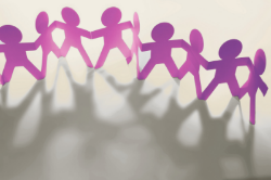 A diverse workforce standing in a circle, holding hands, symbolising unity and togetherness.