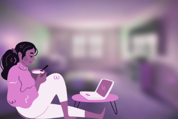 A woman sits on a couch with a laptop and coffee, focused on her work as an accountant from home.