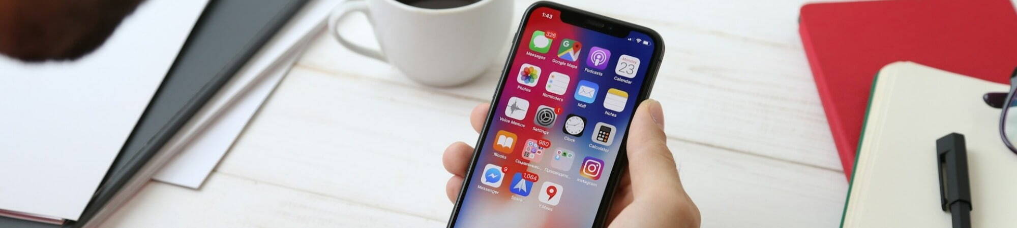 A man using his iPhone X, exploring tips for optimizing battery life effectively.