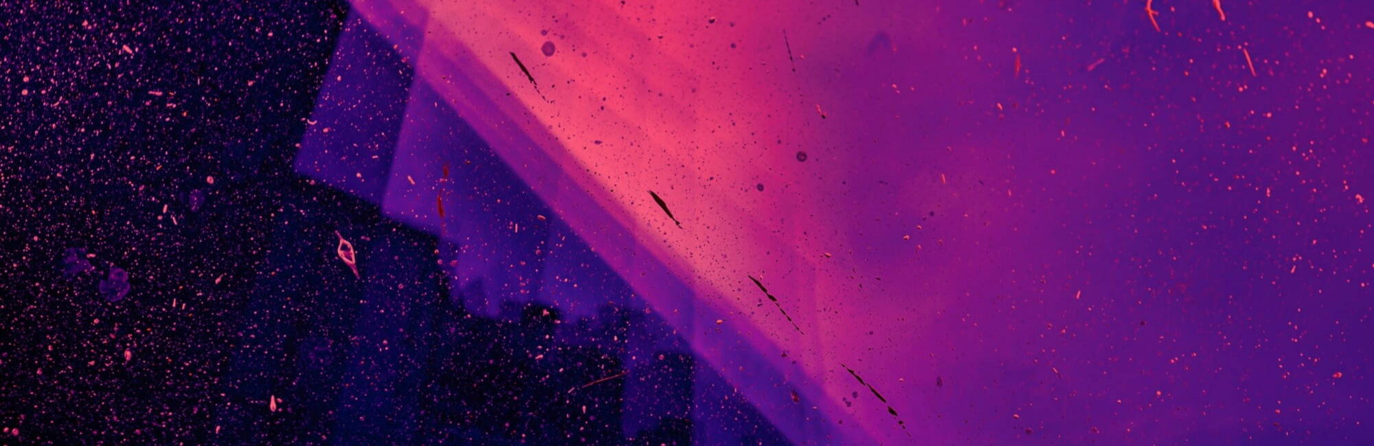 Purple and pink texture background with paint splatters on.