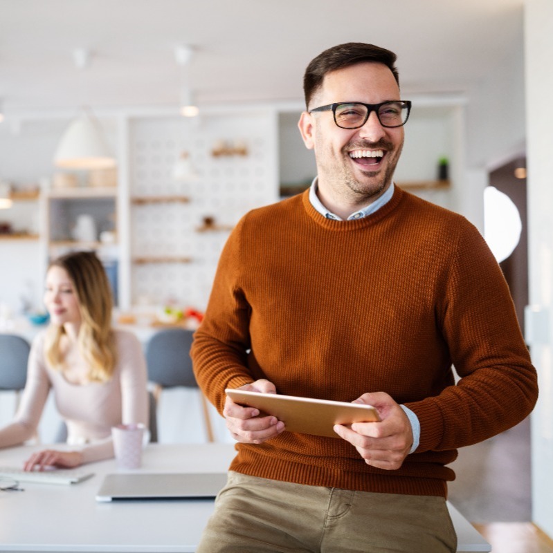 Male accountancy and finance recruitment consultant smiling whilst sat on a desk